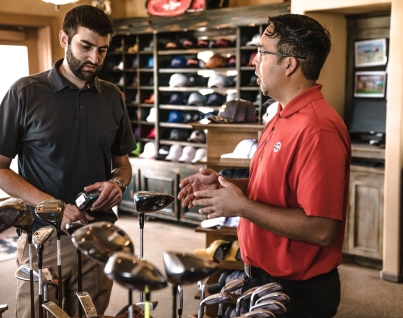 Two men discussing golf clubs